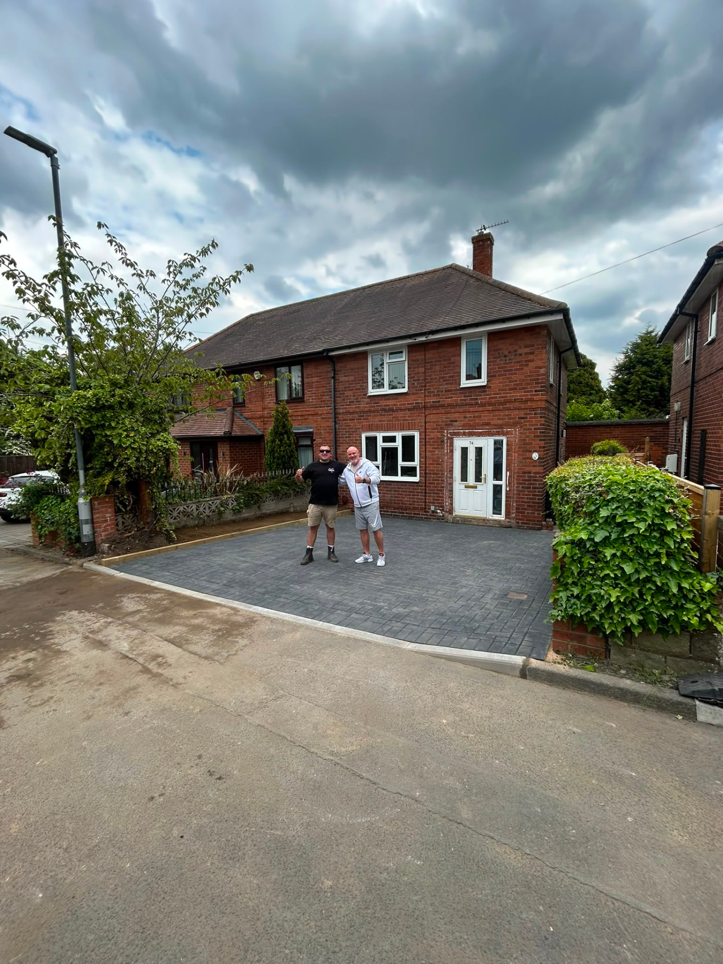 Completed grey block paved driveway in front of a semi detached house