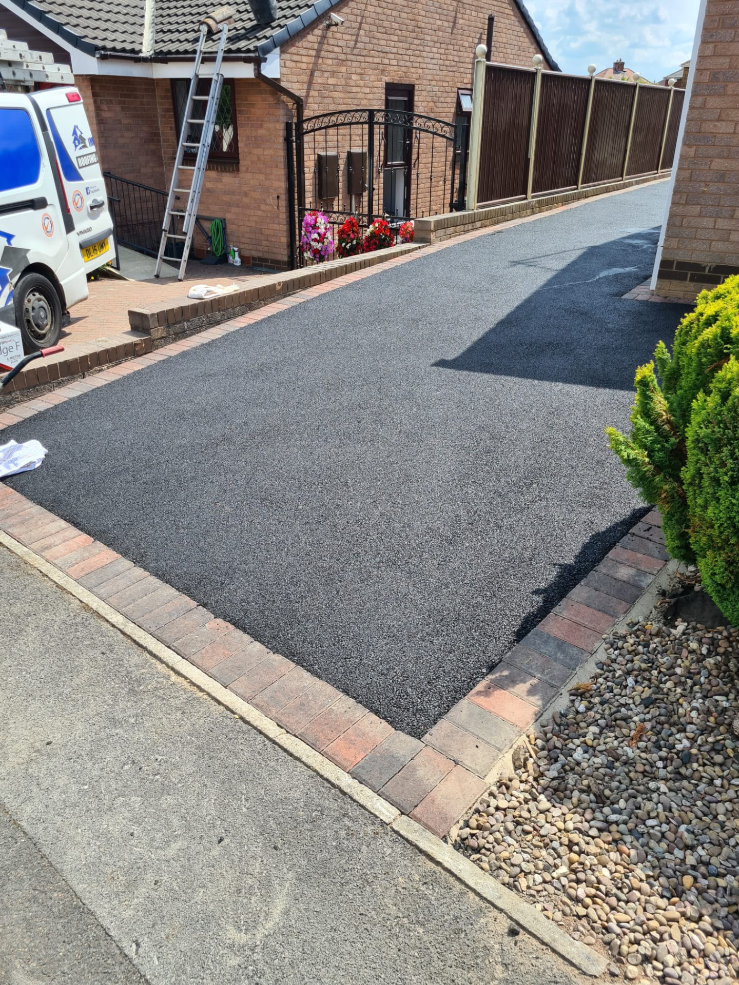 Freshly laid tarmac driveway with brick border