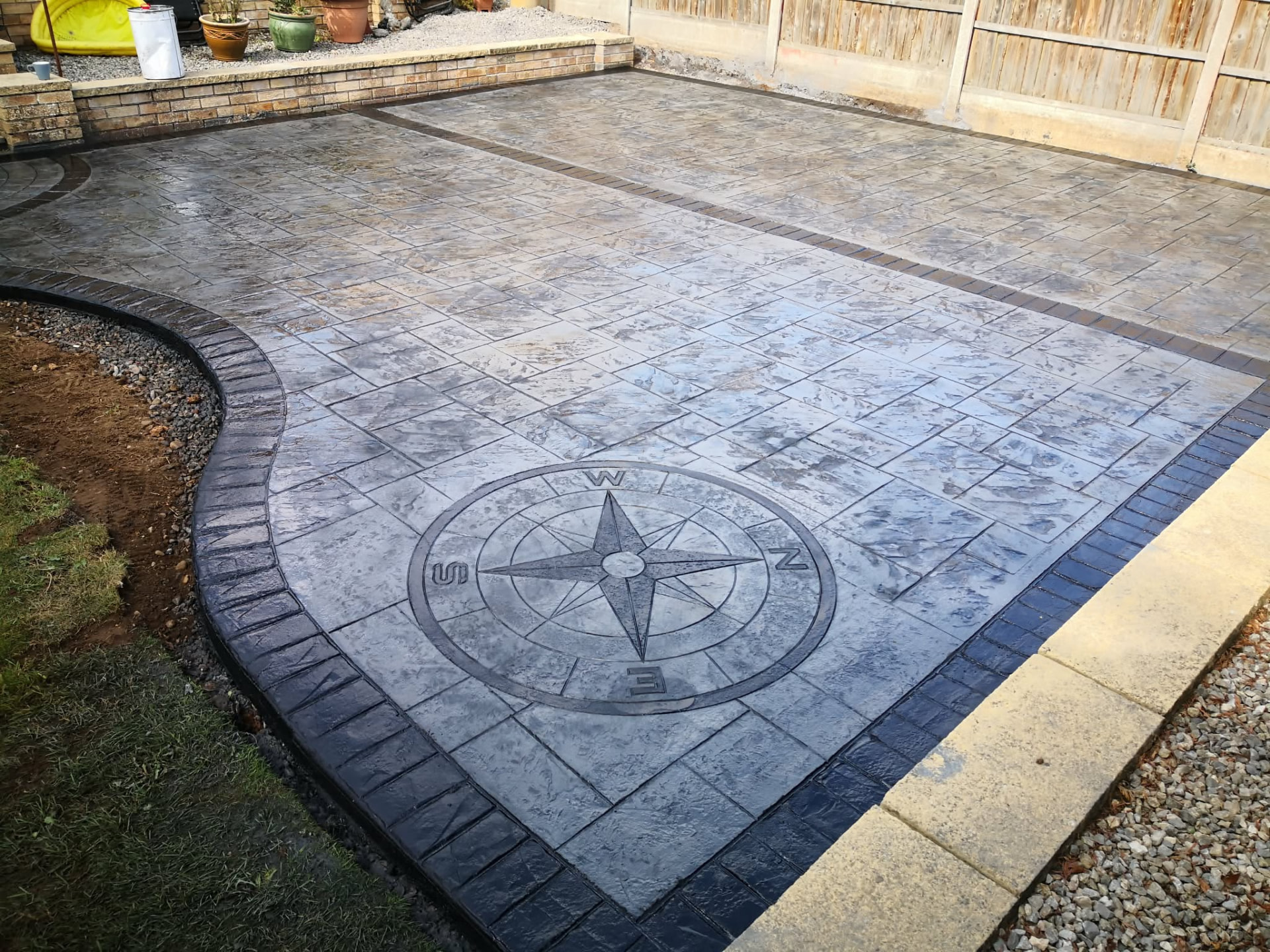 Grey patterned imprinted concrete patio with compass detail