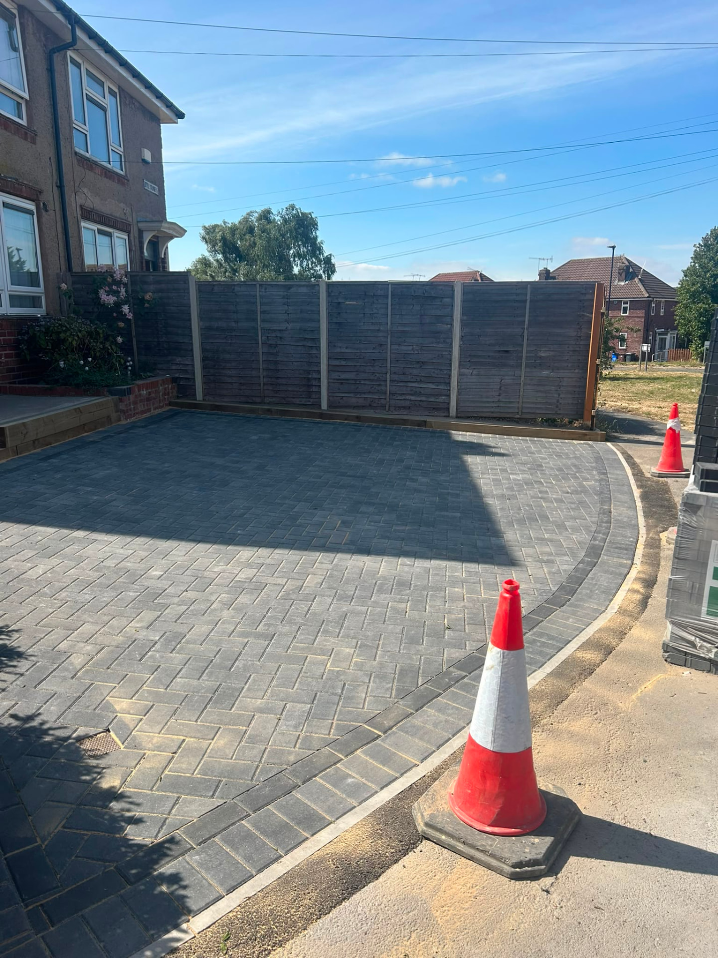 Charcoal block paved driveway with curved edging